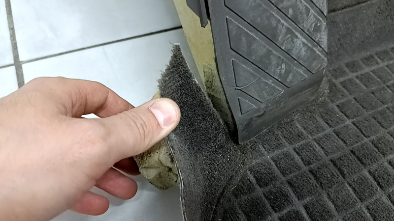Угол покрытия пола с подставкой под ногу для Audi Q5, заметны следы износа.