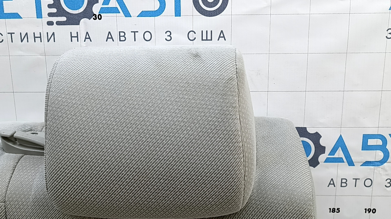 Крупный план подголовника заднего сиденья Toyota Camry, присутствуют незначительные повреждения.