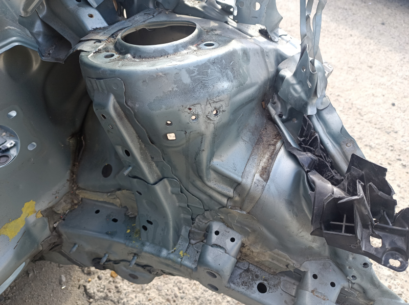 Крупный план передней левой четверти кузова Toyota Prius V с повреждениями, требуется осмотр перед установкой.