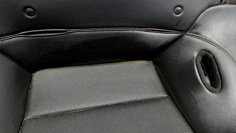 Место у подлокотника на сиденье Ford Mustang, небольшие повреждения и потертости.