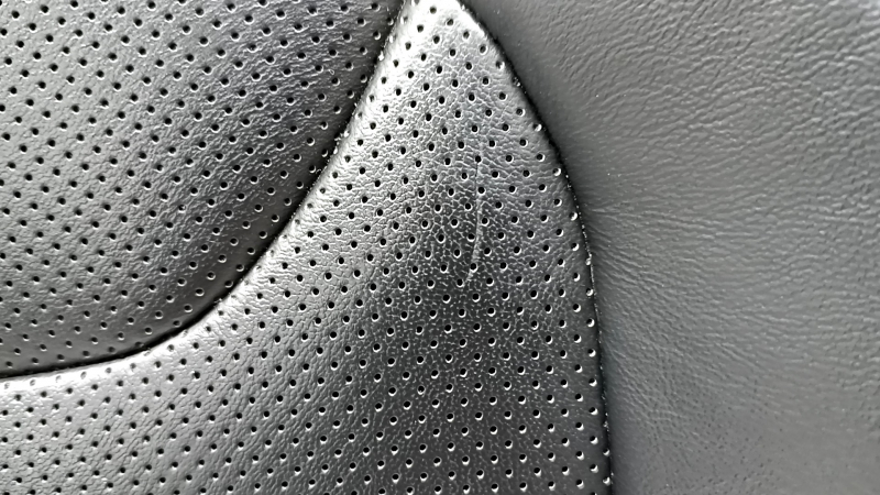 Крупный план потертости на обшивке сиденья Jeep Cherokee, вид сбоку.