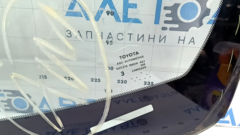 Ближний план оригинального лобового стекла Toyota, видно марку и оригинаютность детали
