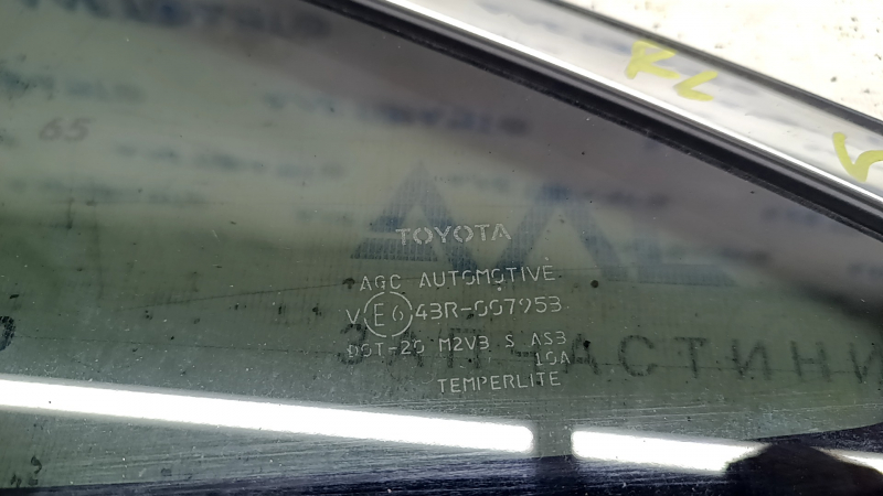 Крупный план маркировки на боковой форточке Toyota Venza, видно оригинальное стекло