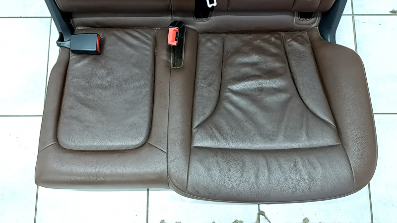 Крупный план сиденья Audi Q5, царапины и примятости видны на обивке.