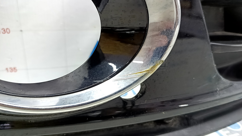 Деталь передней решетки Audi Q5, отчетливо видны повреждения хрома и царапины.