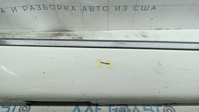 Крупный план поверхности накладки порога с заметными следами использования.