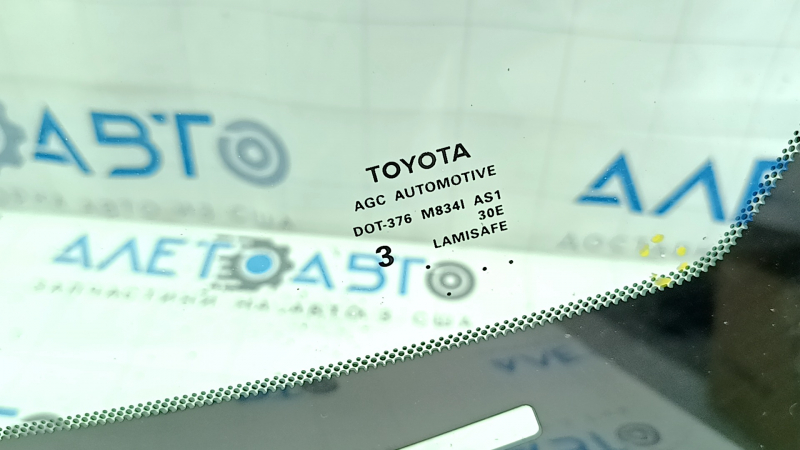 Маркировка на стекле Toyota, показывающая его оригинальность и производителя.