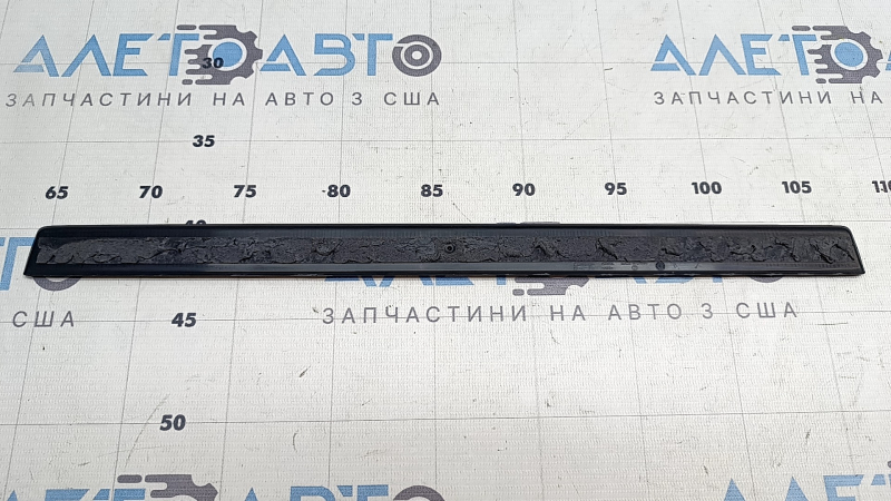 Чёрная часть накладки порога Polestar 2, с естественными следами эксплуатации.