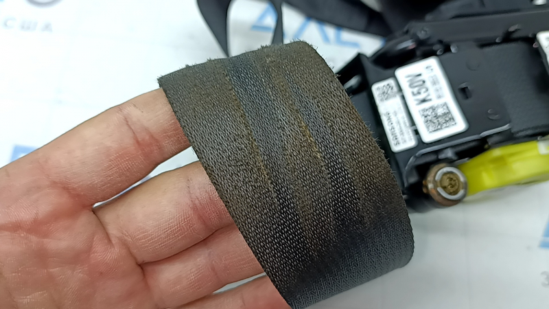 Кадр близкого плана с лицевой стороны водительского ремня безопасности Kia Niro, демонстрирующий следы использования.