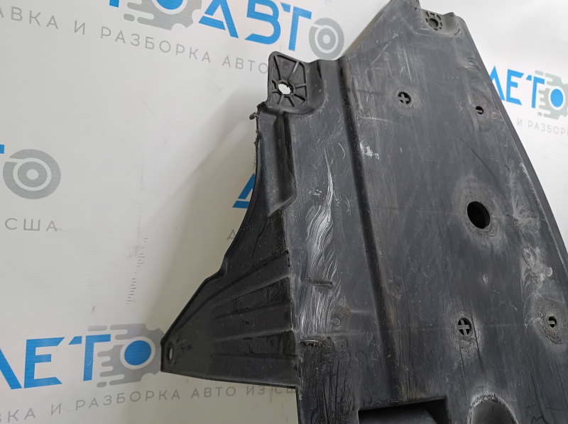 Крупный план поврежденной защиты двигателя Honda Insight с заметными следами эксплуатации.