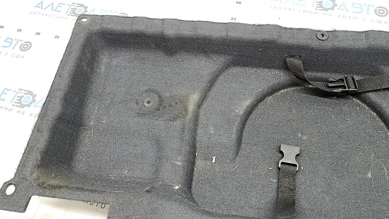 Крупный план покрытия пола багажника BMW X5 F15 с дефектами, вид слева.