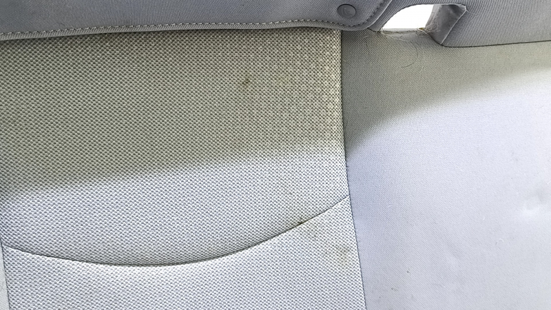 Крупный план ткани сиденья заднего ряда Toyota Prius, видны загрязнения