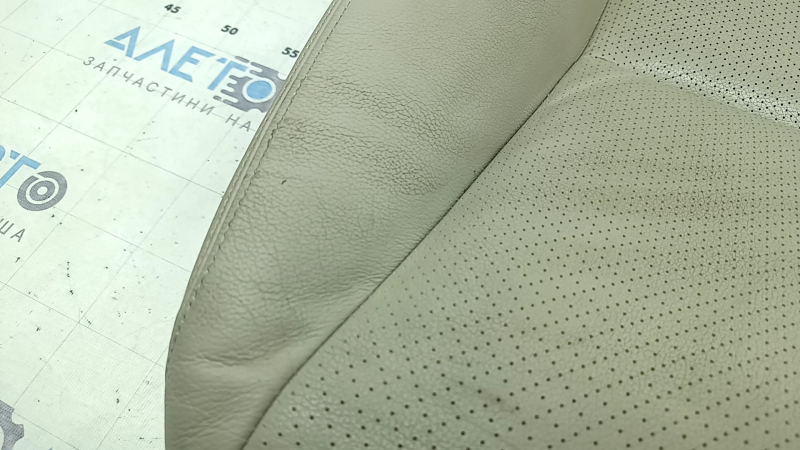 Крупный план повреждений на коже обшивки сиденья Honda Accord, видны следы износа.