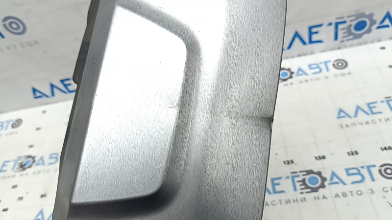 Крупный план замятия на накладке губы бампера BMW X5, показывает состояние поверхности.