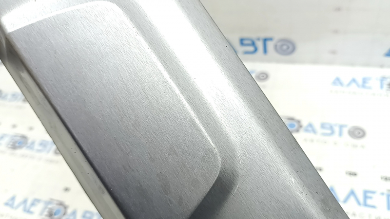 Крупный план повреждения на накладке губы заднего бампера BMW X5, видимые царапины.