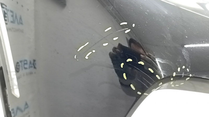 Детальный обзор повреждений на переднем бампере BMW X5, показывающий царапины и трещину.