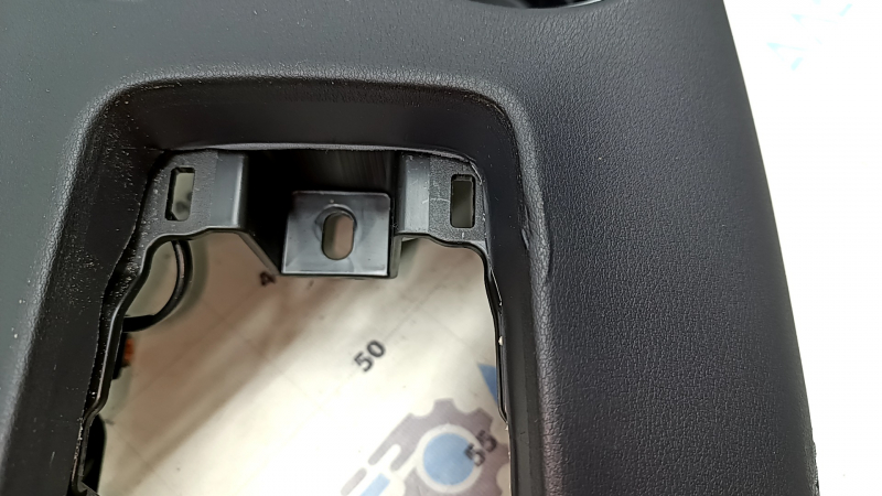 Близкий план верхней части накладки центральной консоли Toyota Venza с небольшими потертостями