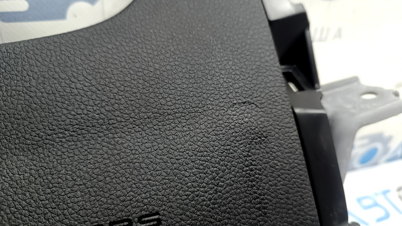 Крупный план поврежденной текстуры подушки безопасности Honda Accord, виден износ.