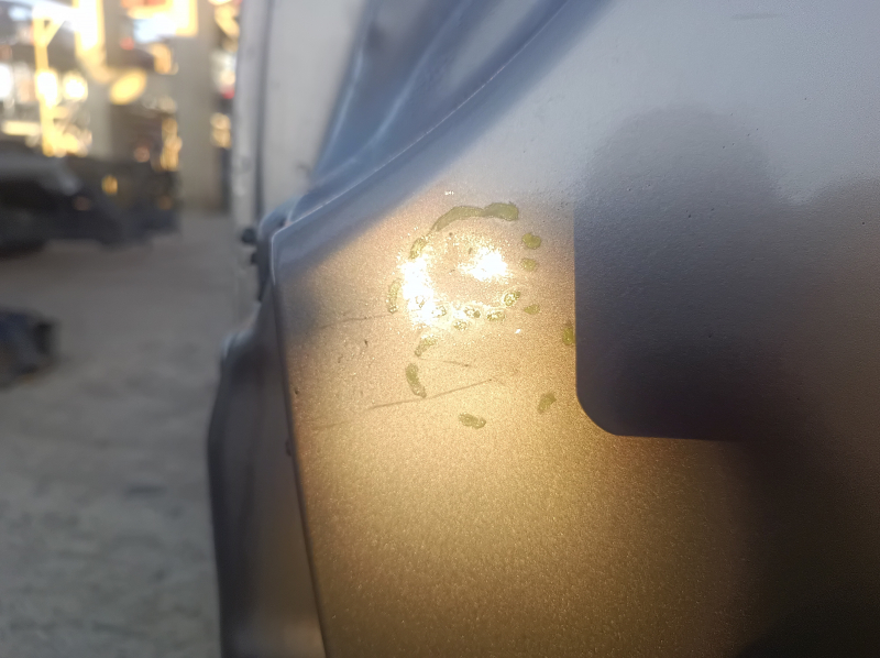 Мелкие дефекты на бежевой четверти Chrysler Pacifica, световые отражения.
