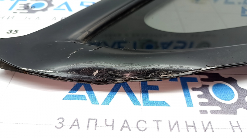 Деталь со следами использования: обрамление боковой форточки Tesla Model 3 2018-2023 с повреждениями.