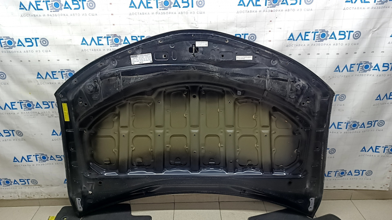 Задняя сторона капота Toyota Camry V50 2012-2014, видно крепление и защитные элементы.