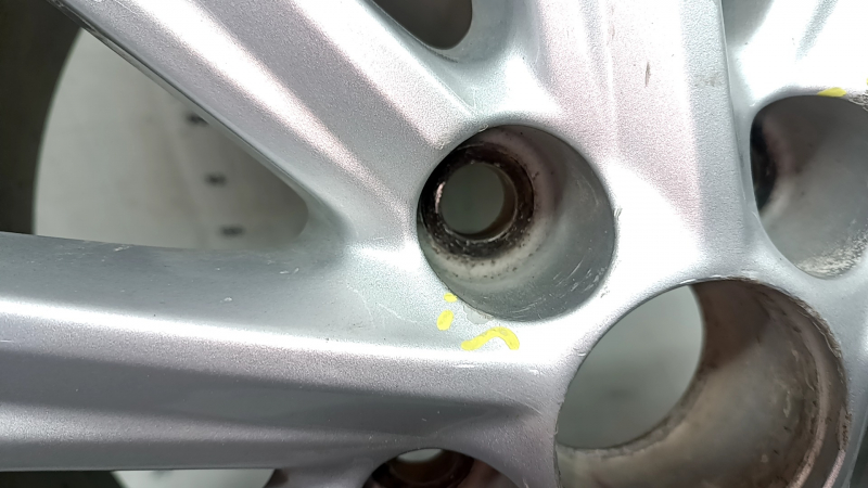 Крупный план крепёжного отверстия диска колёсного Toyota Camry с признаками загрязнений