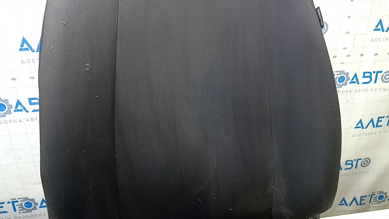 Крупный план поверхности сиденья Nissan Versa, имеются потертости.