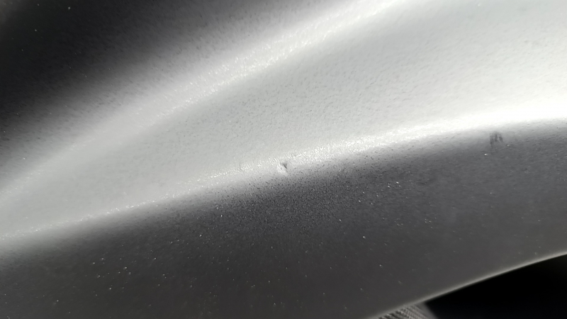 Ближайший план трещин на обшивке двери Tesla Model X, требующей ремонта.