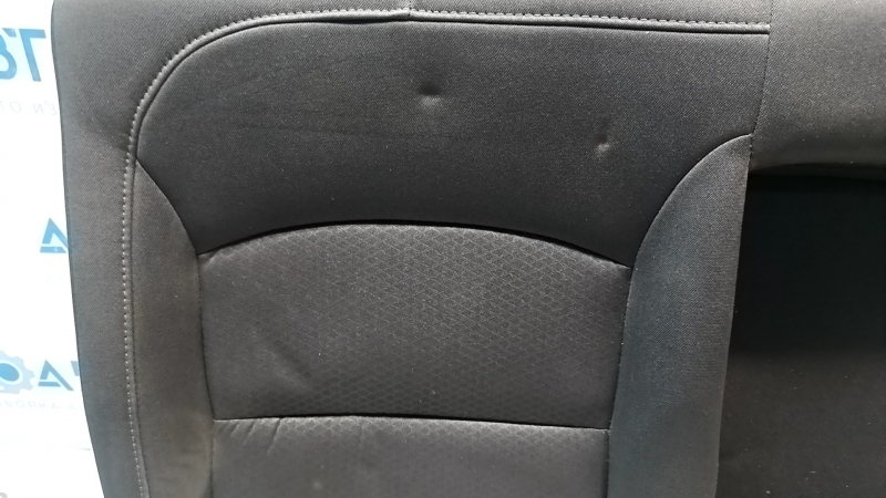 Крупный план спинки сидений Chevrolet Malibu, видимые вмятины на черной ткани, детали в состоянии Б/У.