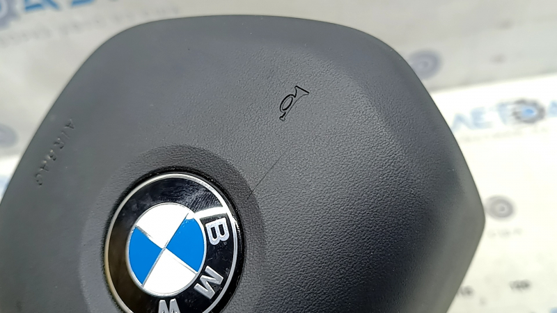 Деталь на заднем фоне - подушка безопасности руля BMW с недостатками.
