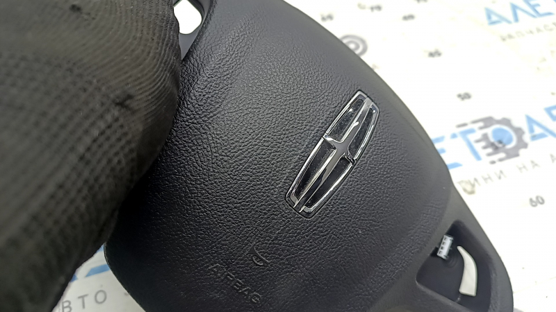 Ручное обследование руля со значком Lincoln MKC, видно его качество и оригинальность.