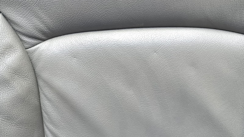 Крупный план дефекта на коже спинки сиденья Chevrolet Malibu