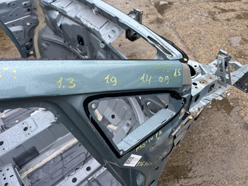 Фрагмент кузова Toyota Prius, с видимыми надписями и признаками ремонта.