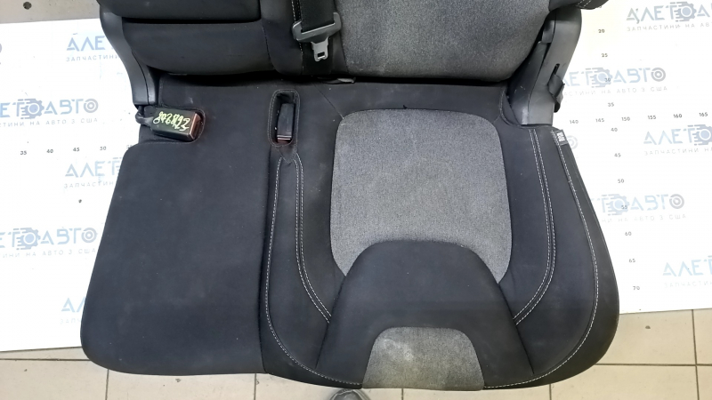 Крупный план сидения заднего ряда Jeep Cherokee, вид на темную ткань и серые вставки.