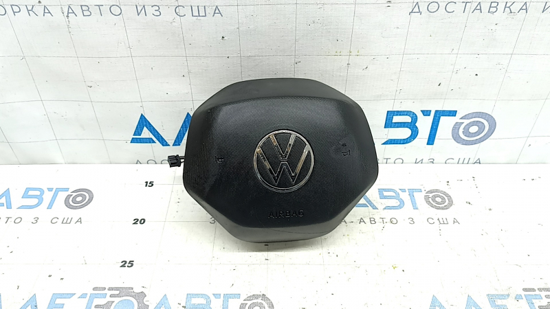 Главный кадр: подушка безопасности для руля Volkswagen Tiguan, 2018-2024, с видимыми следами эксплуатации.