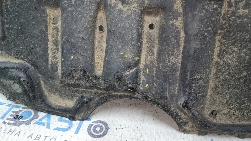 Крупный план повреждения на защите двигателя Toyota Camry, замечены надрывы.