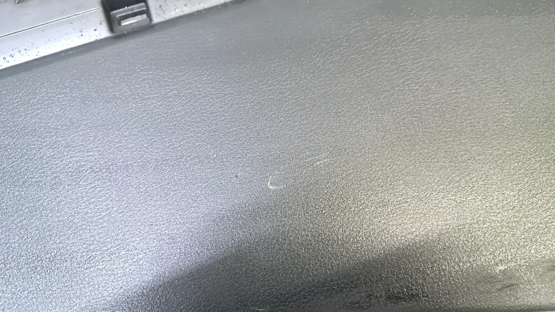 Крупный план на поверхность боковой накладки центральной консоли Mazda CX-30 2020-2021, видны следы эксплуатации