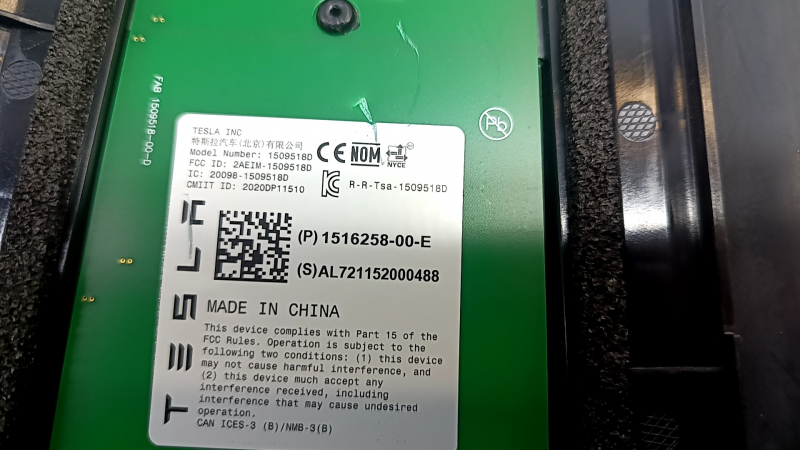 Метка на запчасти с оригинальным номером Tesla, фон черный.