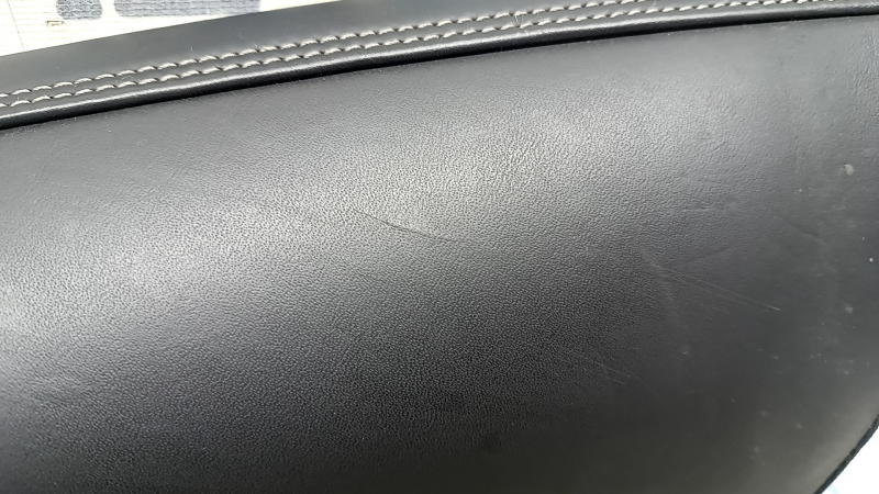 Крупный план на боковушку заднего сиденья Volvo XC60, видно потертости и царапины на коже.