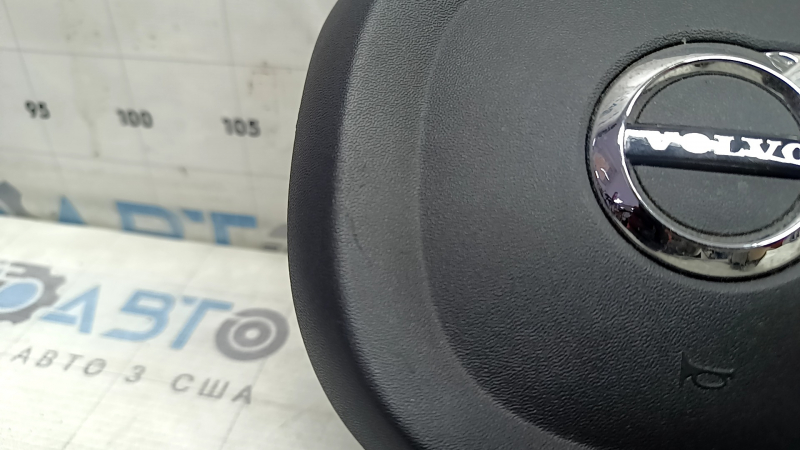 Крупный план логотипа Volvo на подушке, показывающий состояние детали.