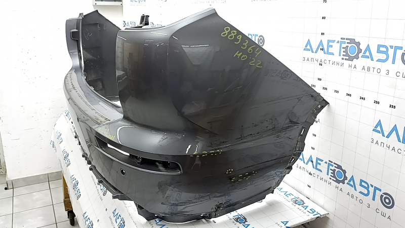 Бампер задний Mitsubishi Outlander 22-26 в графитовом цвете с повреждениями, ракурс сбоку.