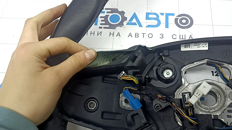 Крупный план на нижнюю часть руля BMW 3 G20, видно состояние обивки стеклянным покрытием.