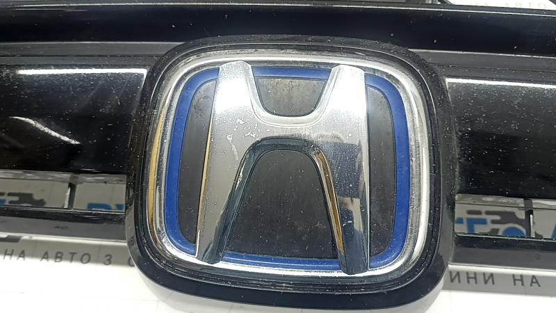 Логотип Honda с близкого расстояния на решетке радиатора