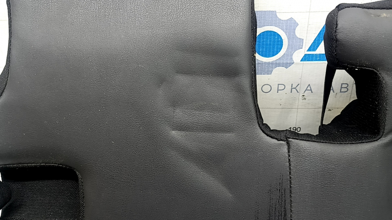 Близкий план замятия на коже подушки заднего ряда сидений.