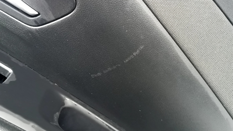 Близкий план царапин на обшивке двери задней правой Hyundai Tucson, видно естественное износ.