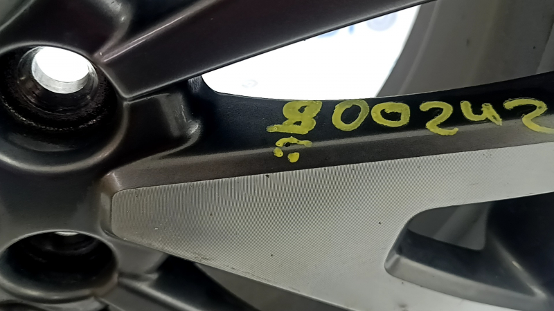 Близкий план детали с нанесением номера 900242 на диске Ford Escape.