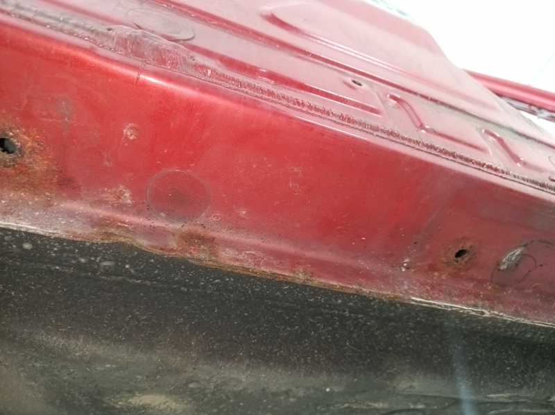 Крупный план ржавчины на стойке кузова Toyota Camry v40, выявленные дефекты.